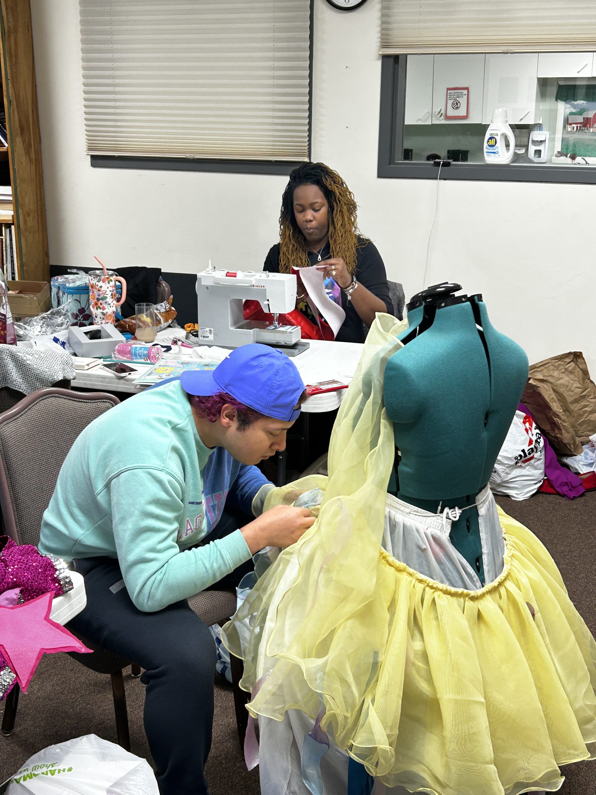 Costumer and assistant work on costume pieces.