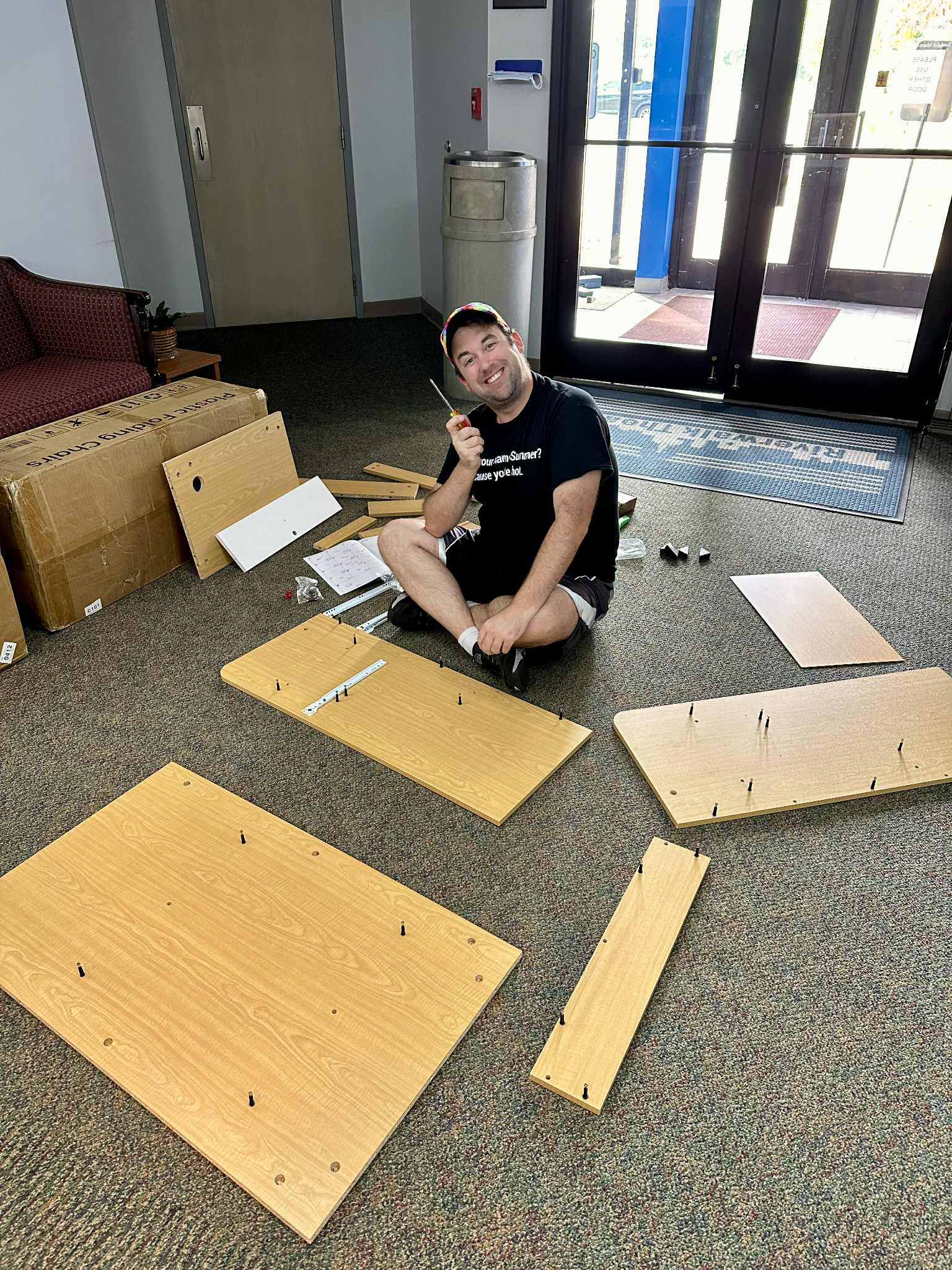 A volunteer puts together a desk for a scene