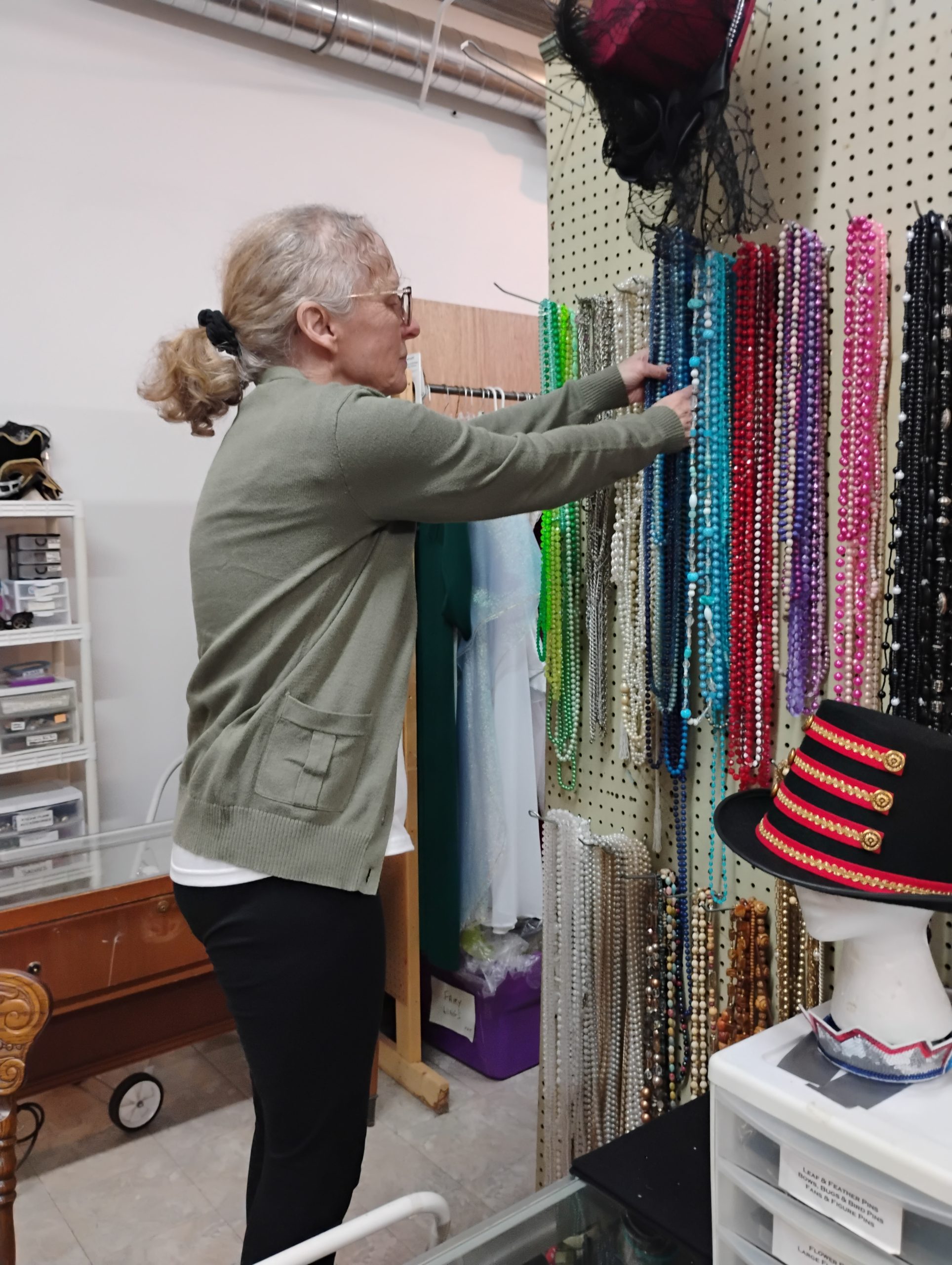 A Costume Shop volunteer organizes necklaces