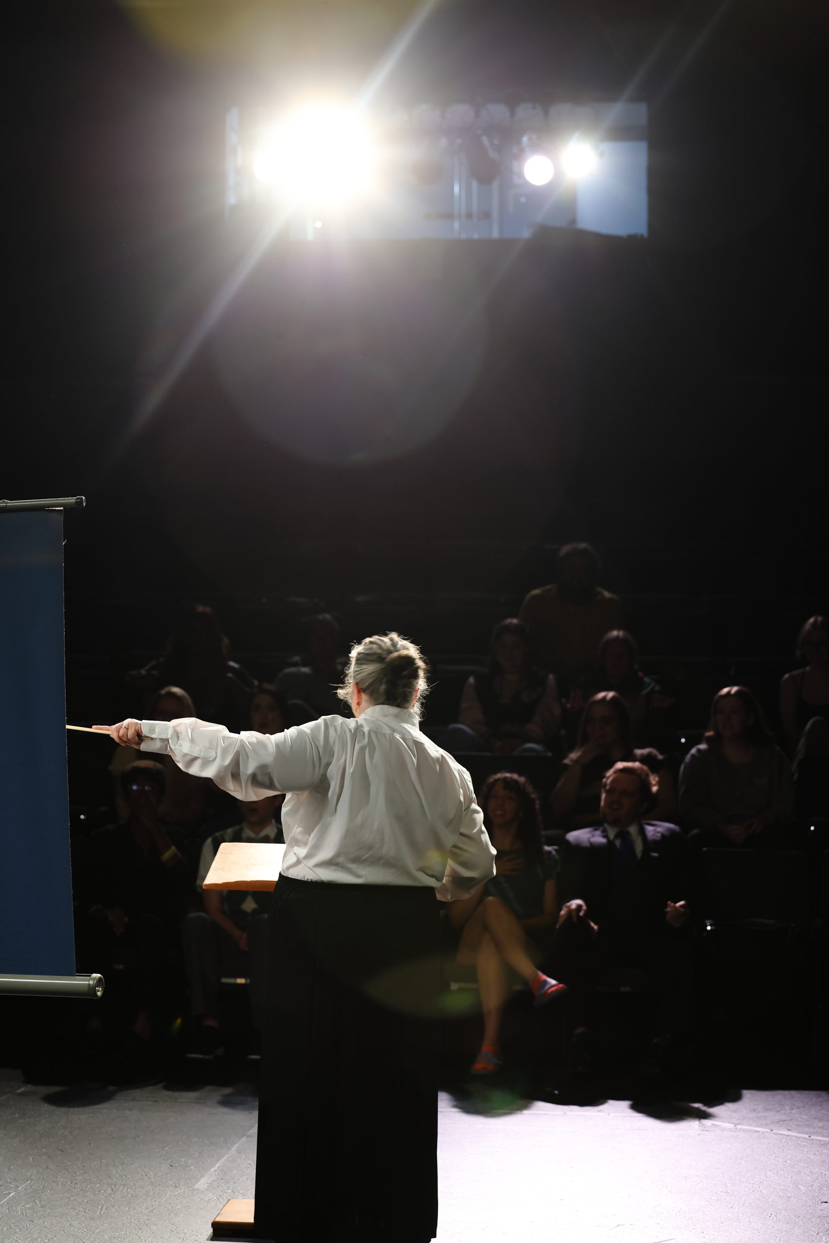 Promo photo for Reefer Madness. A lecturer stands in front of a seated audience in an auditorium.