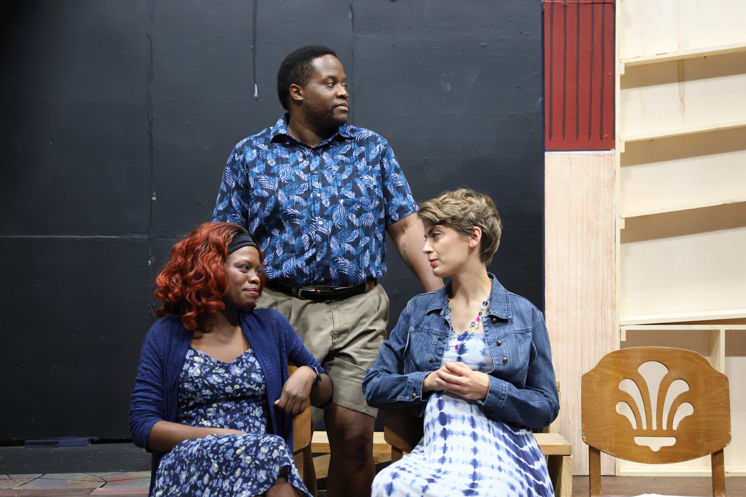 rehearsal photo of two women talking while a man stands nearby