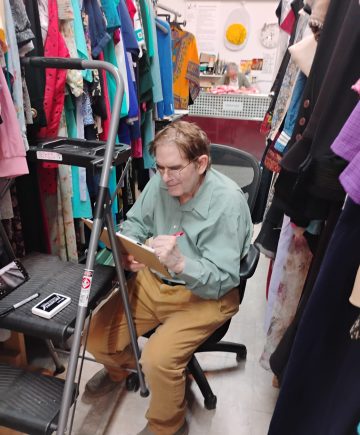 A Costume Shop volunteer assists with inventory